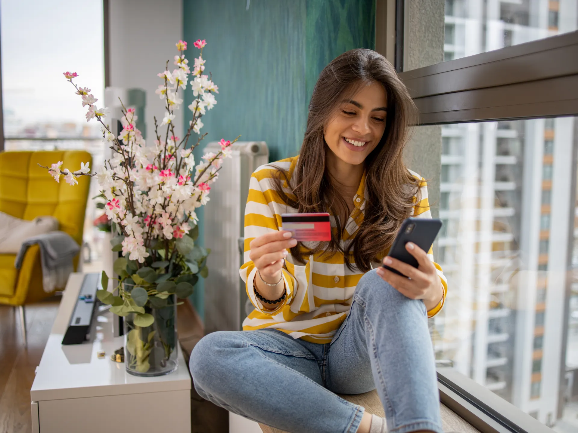 A woman shopping online with her card and phone
